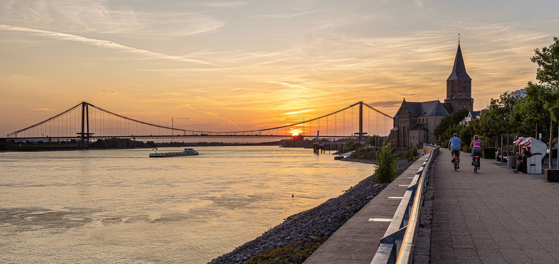 Container auf einem internationalen Hafengelände bei Sonnenaufgang – Symbolbild für Import, Export und Zollabwicklung